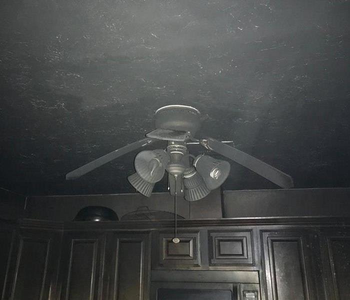 blackened kitchen ceiling, cabinets and fan