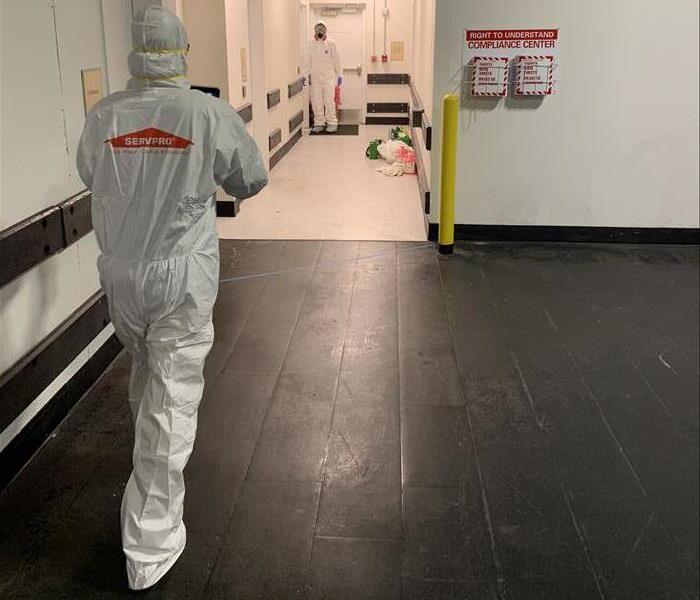 man in white PPE in warehouse