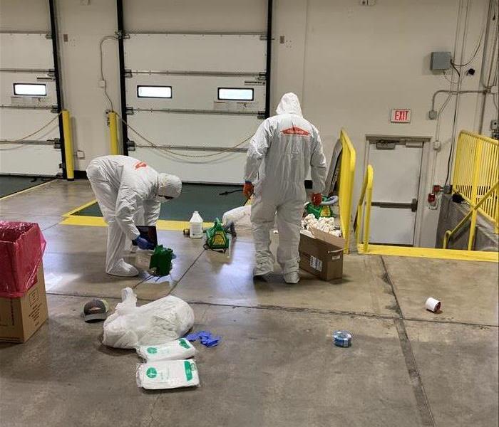 men in white PPE in warehouse
