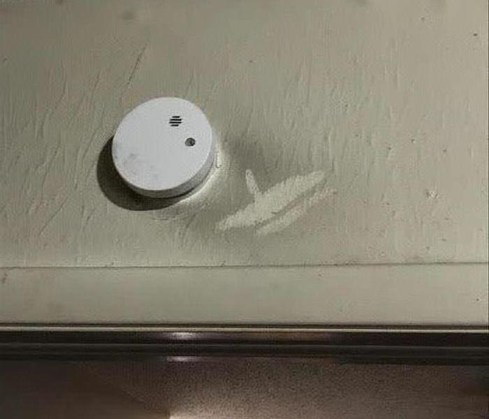 smoke alarm on soot and fire damaged wall