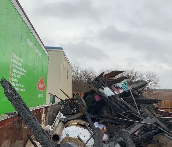 green truck dumpster full of debris