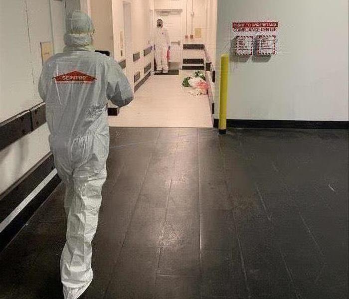 commercial hallway, man in white PPE